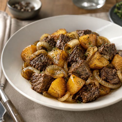 Beef with Onions and Potatoes cooked with olive oil, salt, and tender onions in a rustic bowl