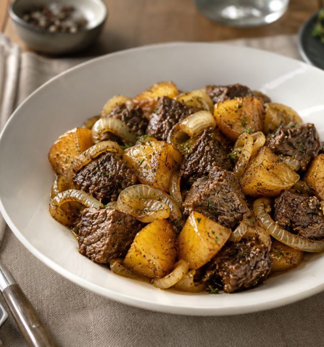 Beef with Onions and Potatoes cooked with olive oil, salt, and tender onions in a rustic bowl